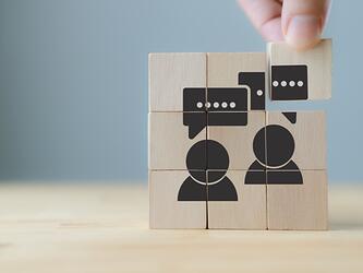 speech bubbles and outlines of people on wooden blocks